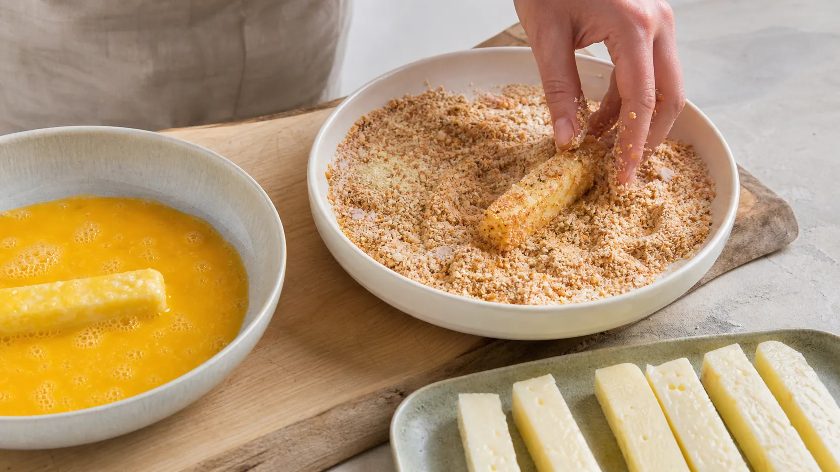 Halloumi-Sticks werden in Ei und Mandelmehl-Panade gewendet