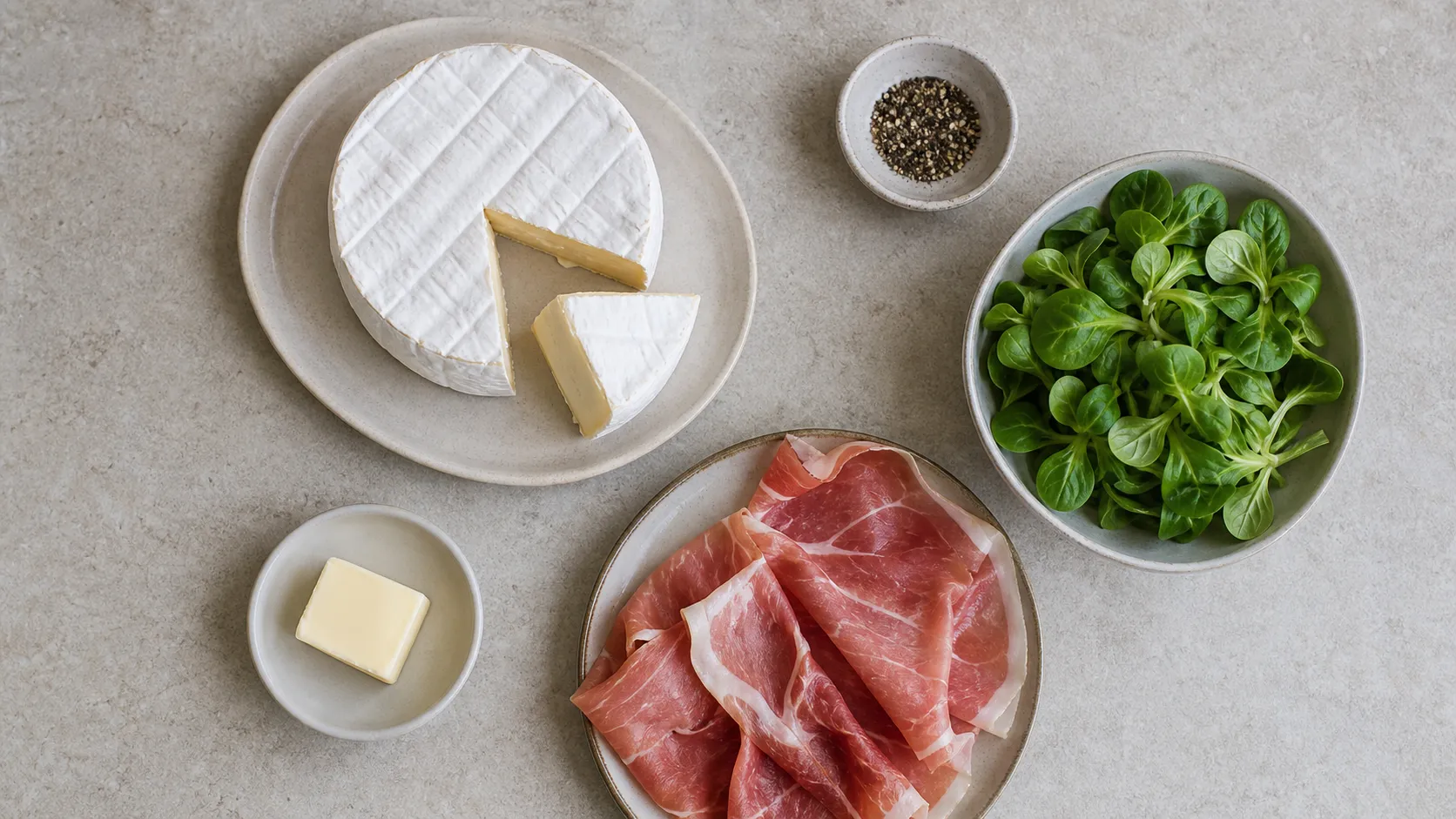 Zutaten: Camembert, luftgetrockneter Schinken, Butter, Pfeffer, Salatblätter