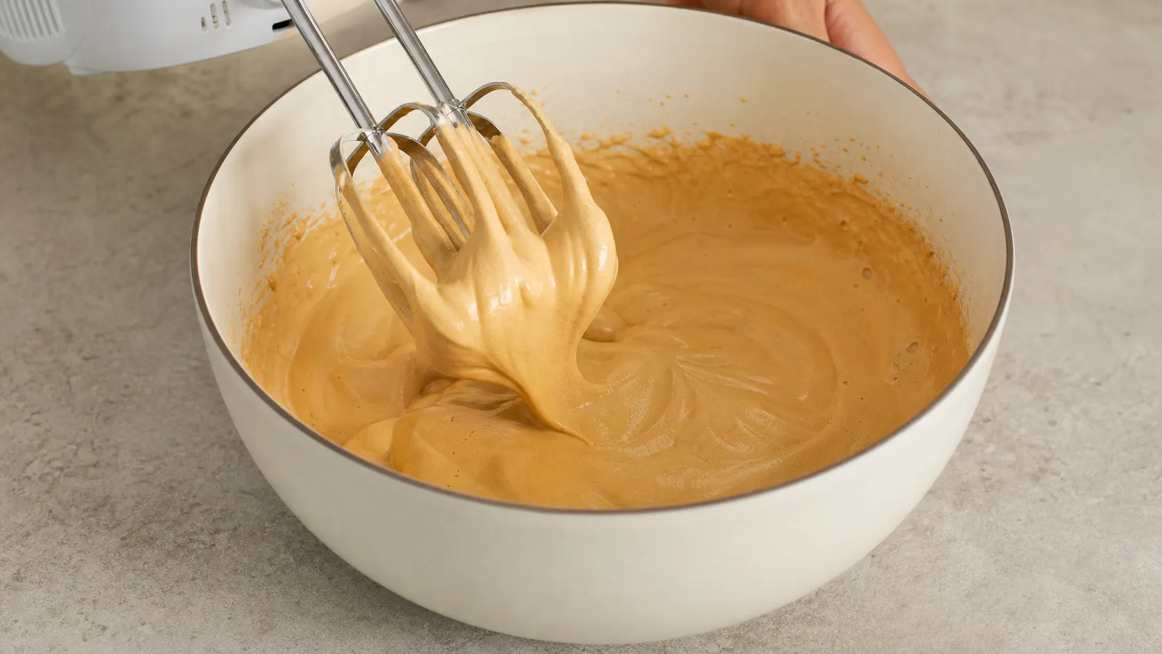 Instantkaffee, Erythrit und heißes Wasser werden mit dem Handmixer zu einer hellen, festen Creme aufgeschlagen