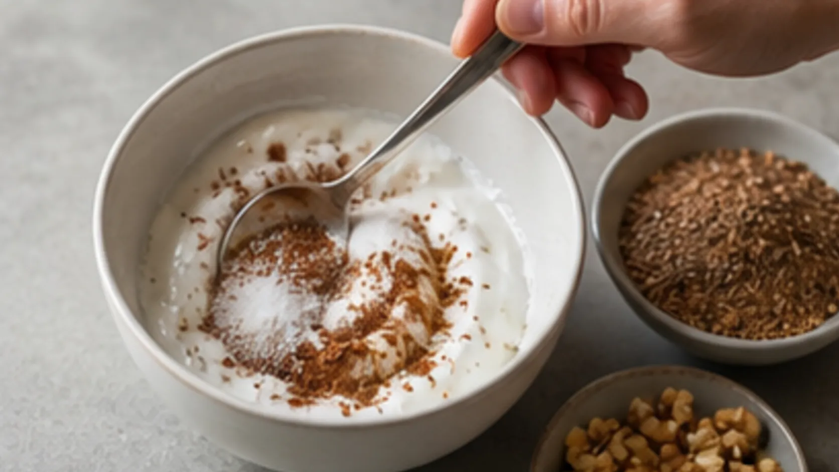 Kokosjoghurt wird mit Zimt und Erythrit für eine Keto-Frühstücksbowl verrührt