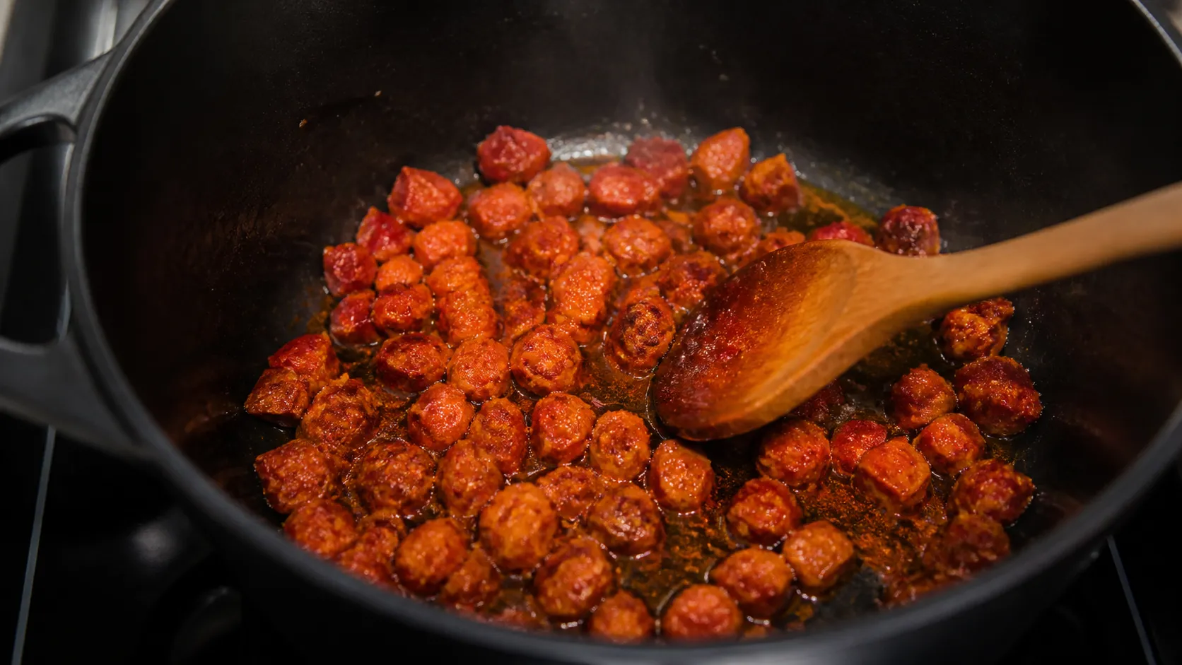Chorizo-Würfel braten in einem Topf aus und geben rotes Paprikafett ab