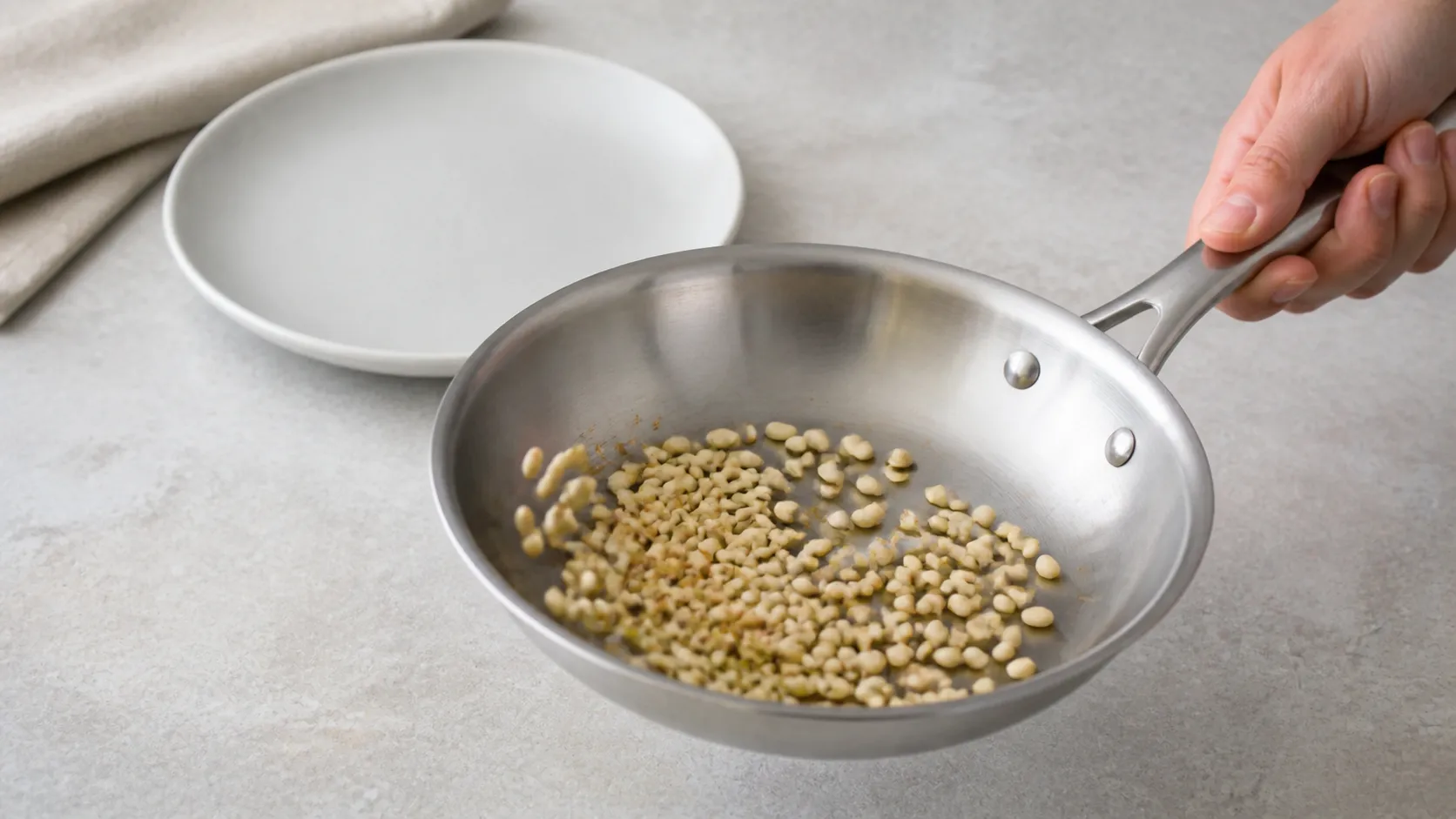 Pinienkerne werden in einer trockenen Pfanne goldbraun geröstet