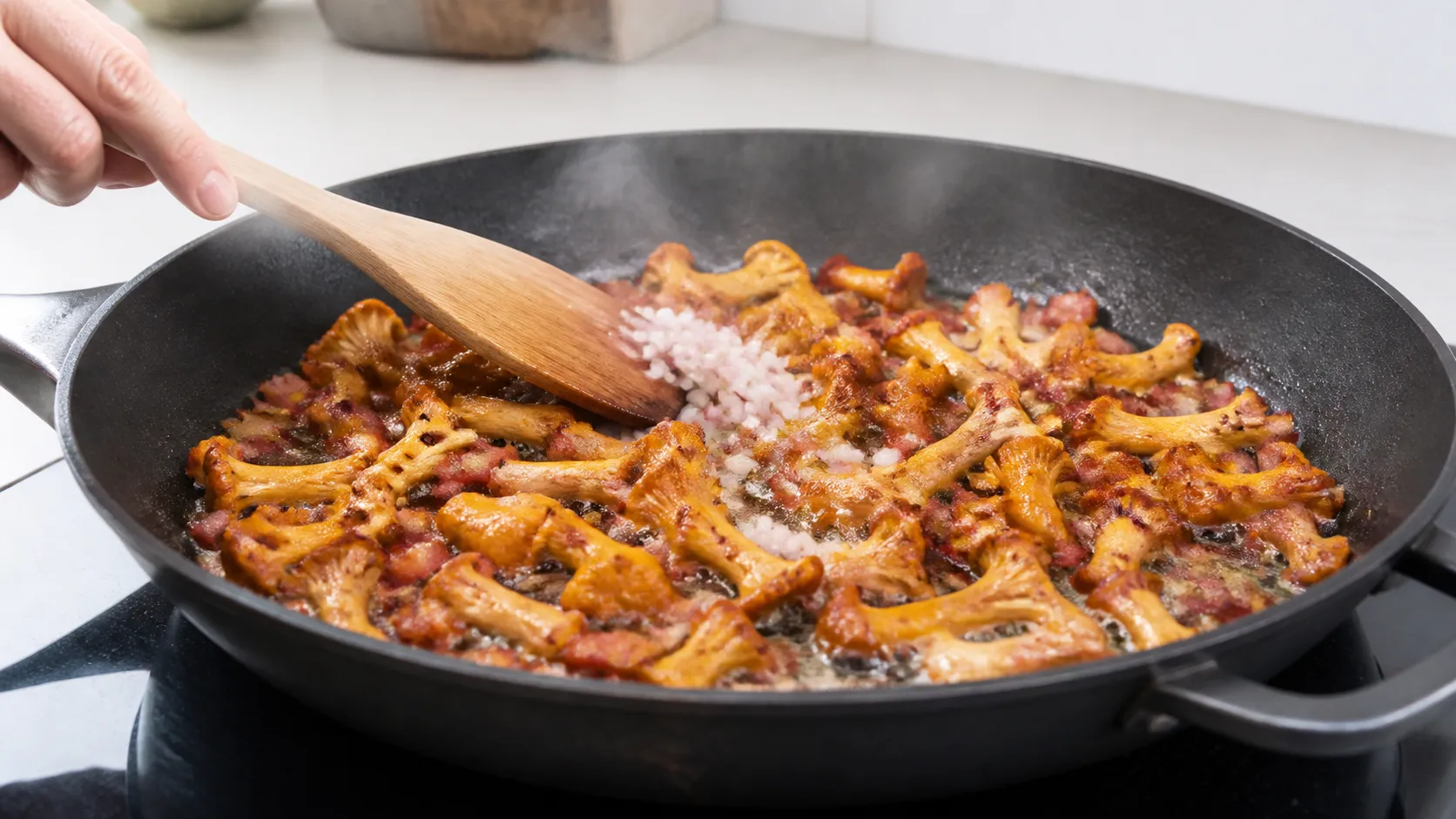 Pfifferlinge braten ohne Deckel in einer heißen Pfanne mit ausgelassenen Speckwürfeln