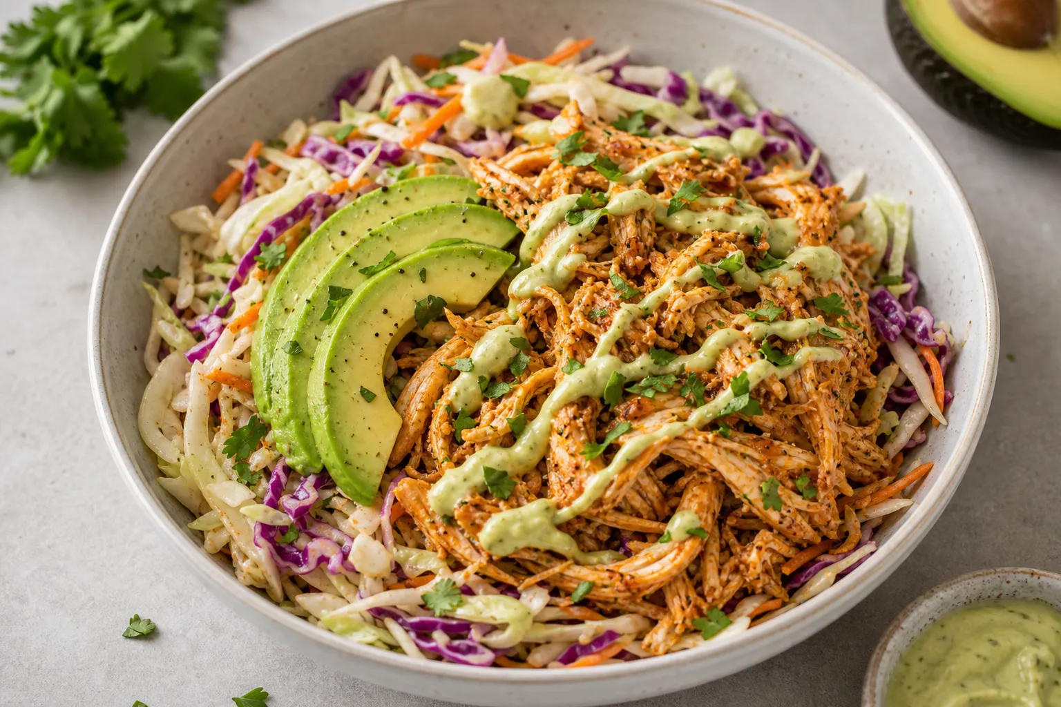 Keto Pulled Chicken Bowl mit buntem Krautsalat, Avocado und geräuchertem Paprika in einer Schüssel