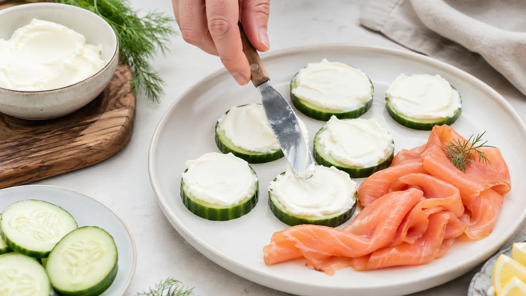 Frischkäse auf Gurkenscheiben dressieren und Räucherlachs auflegen für den Keto-Frühstücksteller