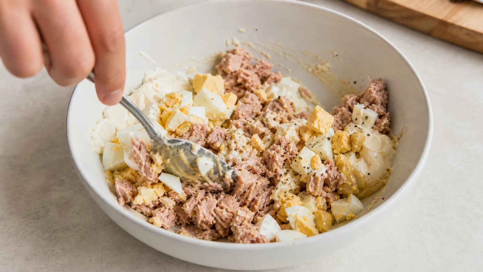 Thunfisch, gehacktes Ei, Mayonnaise und Senf werden in einer Schüssel vermengt