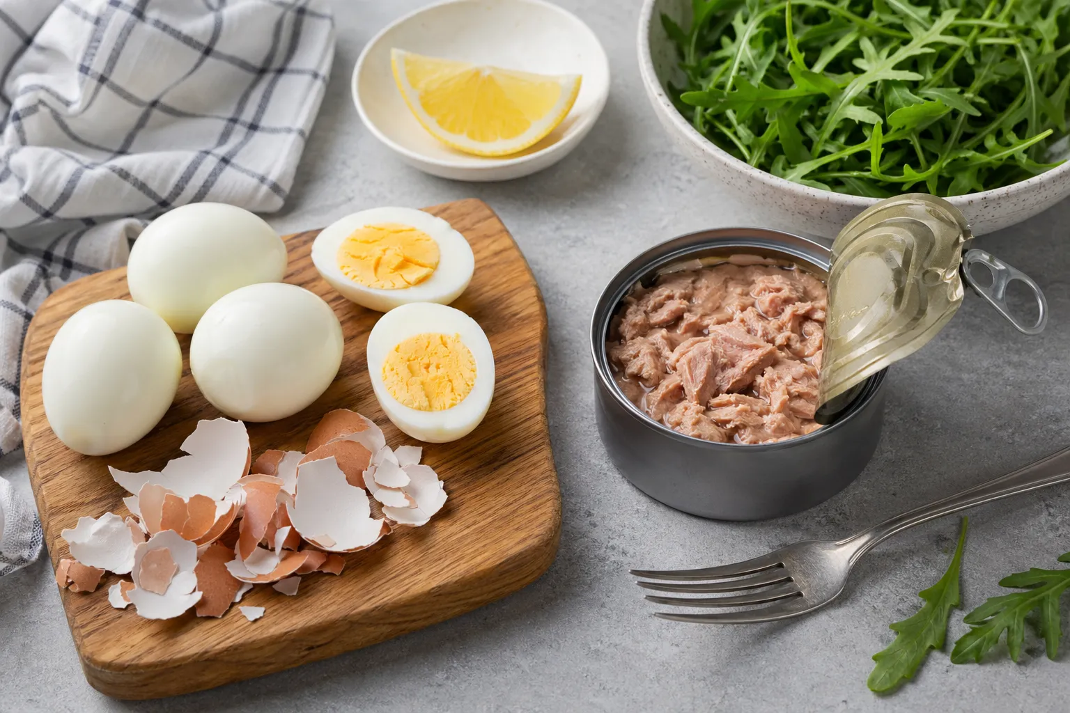 Hartgekochte Eier schälen neben einer offenen Thunfischdose für das Keto-Mittagessen