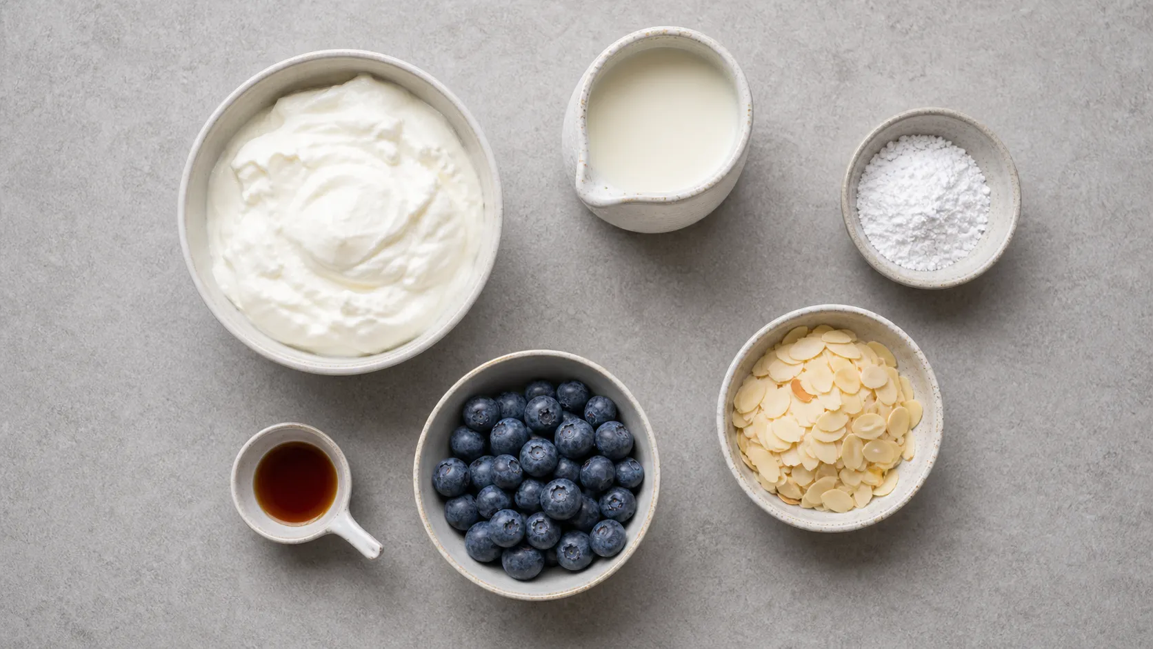 Zutaten für Keto-Vanille-Quark: Quark, Sahne, Erythrit, Vanille, Heidelbeeren und Mandelblättchen